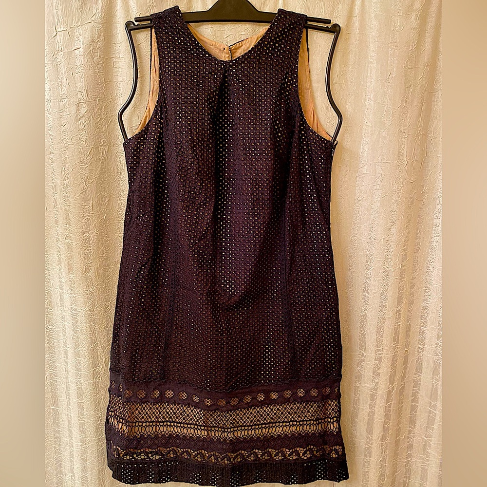 Black shift dress, nude lining, sleeveless.